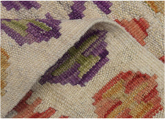 A close-up of a handmade Afghan Maimana kilim runner featuring geometric patterns in vibrant colors.