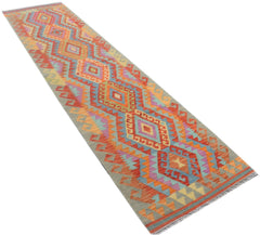 A handmade Afghan Maimana Kilim runner featuring a vibrant geometric pattern in wool.