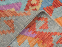 A handmade Afghan Maimana kilim runner featuring a geometric pattern in orange, purple, and blue.