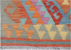Handmade Afghan Maimana kilim runner featuring a colorful geometric pattern and fringed edges.
