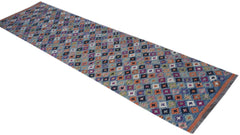 A handmade Afghan Maimana wool runner rug featuring a colorful geometric pattern.