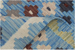 A handmade Afghan Maimana kilim runner featuring a blue background with geometric floral patterns.
