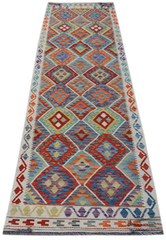 A handmade Afghan Maimana wool runner rug featuring a colorful geometric diamond pattern.