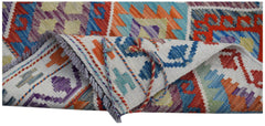 A handwoven Afghan Maimana kilim runner featuring vibrant geometric patterns in wool.