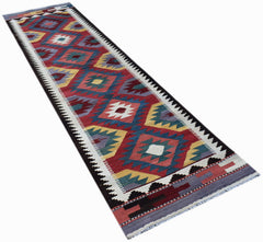 A handmade Afghan Maimana wool runner rug featuring a colorful geometric diamond pattern.