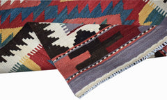 A handwoven Afghan Maimana wool kilim runner featuring geometric patterns in red, blue, and yellow.