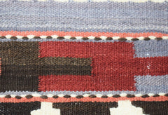A close-up of a handmade Afghan Maimana kilim runner featuring geometric patterns in wool.