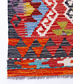 Handwoven Afghan Maimana kilim runner featuring a vibrant geometric pattern in wool.