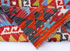 A handwoven Afghan Maimana kilim runner featuring a vibrant geometric pattern in wool.