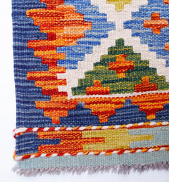 Handwoven Afghan Maimana wool kilim runner featuring vibrant geometric patterns in a flat weave.