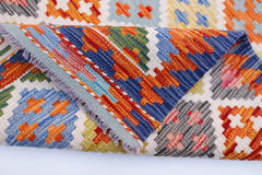 A handwoven Afghan Maimana wool kilim runner featuring a colorful geometric pattern.
