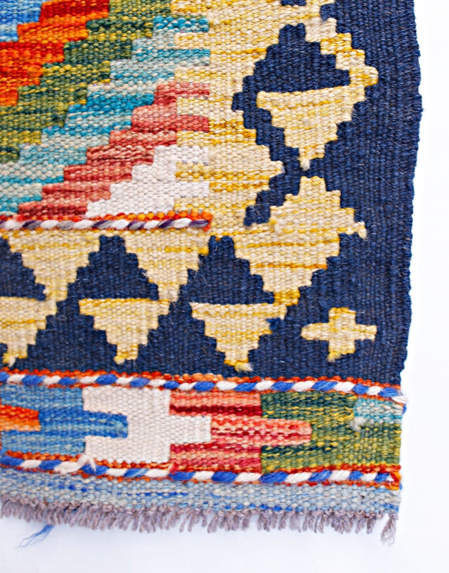 A handmade Afghan Maimana kilim runner featuring geometric patterns in vibrant wool colors.