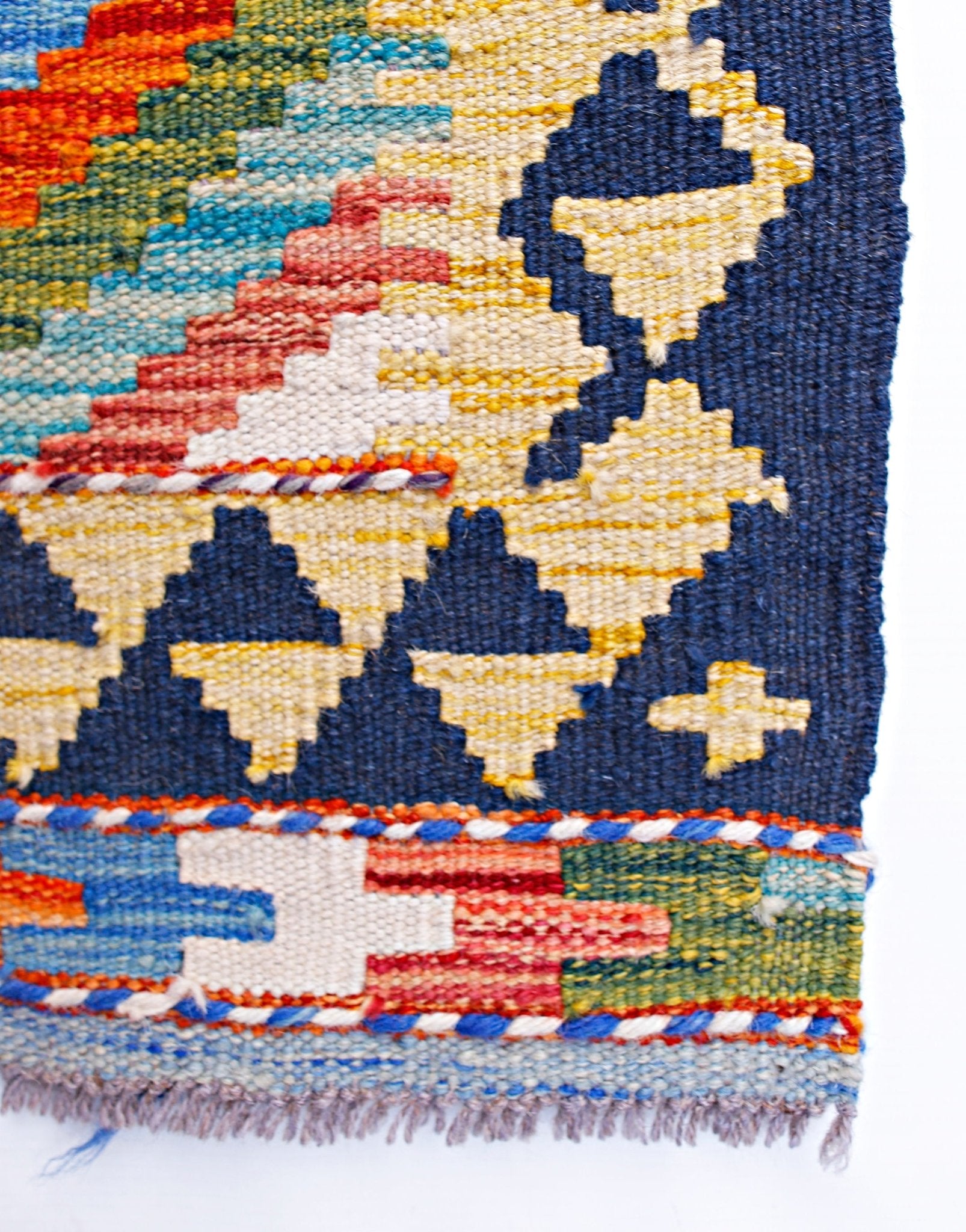 A handmade Afghan Maimana kilim runner featuring geometric patterns in vibrant wool colors.