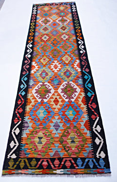 Handwoven Afghan Maimana wool runner featuring a vibrant geometric pattern in a flatweave style.