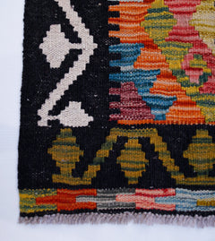 Handwoven Afghan Maimana wool runner featuring a black border with geometric patterns in vibrant colors.