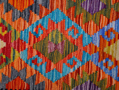 Handwoven Afghan Maimana kilim runner featuring a vibrant geometric pattern in wool.