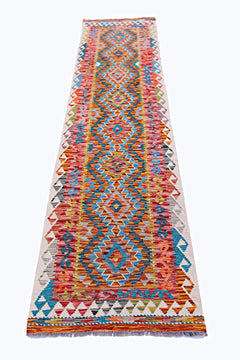 A handmade Afghan Maimana wool runner featuring a vibrant, multi-colored geometric diamond pattern.