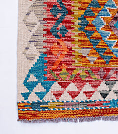 Handwoven Afghan Maimana wool kilim runner featuring a vibrant geometric pattern and fringe edges.