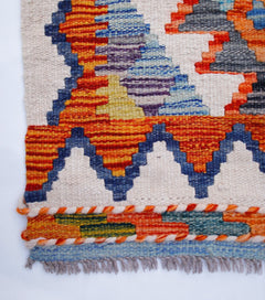 Handwoven Afghan Maimana kilim runner featuring vibrant geometric patterns in wool.