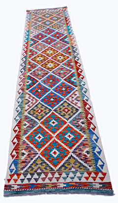 A handmade Afghan Maimana wool runner rug featuring a colorful geometric diamond pattern.