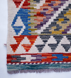 Handwoven Afghan Maimana kilim runner featuring a colorful geometric pattern on a cream background.