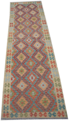 A handmade Afghan Maimana wool runner rug featuring a geometric diamond pattern in vibrant colors.