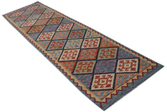 A handmade Afghan Maimana wool runner rug featuring a colorful geometric diamond pattern.