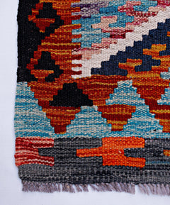 Handwoven Afghan Maimana wool runner featuring a vibrant geometric pattern in multi-colored tones.