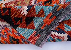 A handwoven Afghan Maimana kilim runner featuring vibrant geometric patterns in wool.