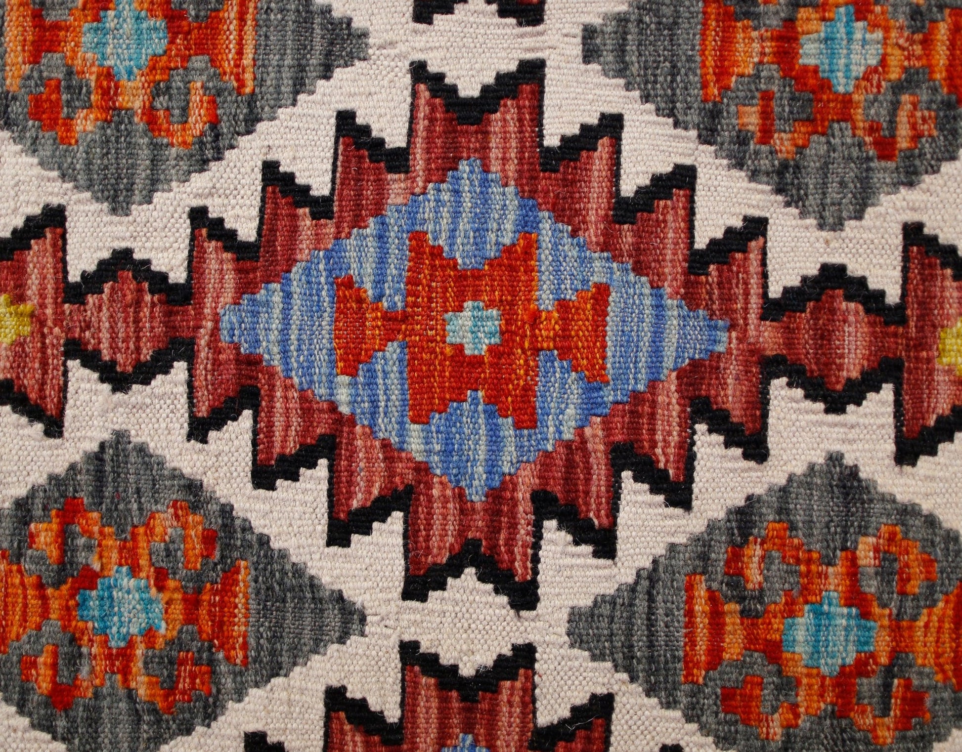 Handwoven Afghan Maimana kilim runner featuring a geometric pattern in red, blue, and grey wool.