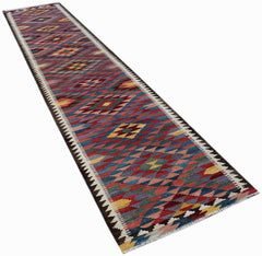A handmade Afghan Maimana wool runner rug featuring a colorful geometric diamond pattern.