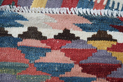 A close-up of a handwoven Afghan Maimana kilim runner featuring geometric patterns in wool.
