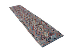 A handmade Afghan Maimana wool runner rug featuring a colorful geometric diamond pattern.