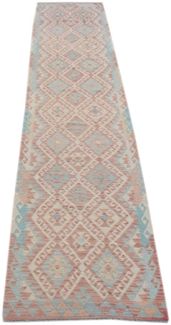 A handmade Afghan Maimana wool runner rug featuring a geometric diamond pattern in soft colors.