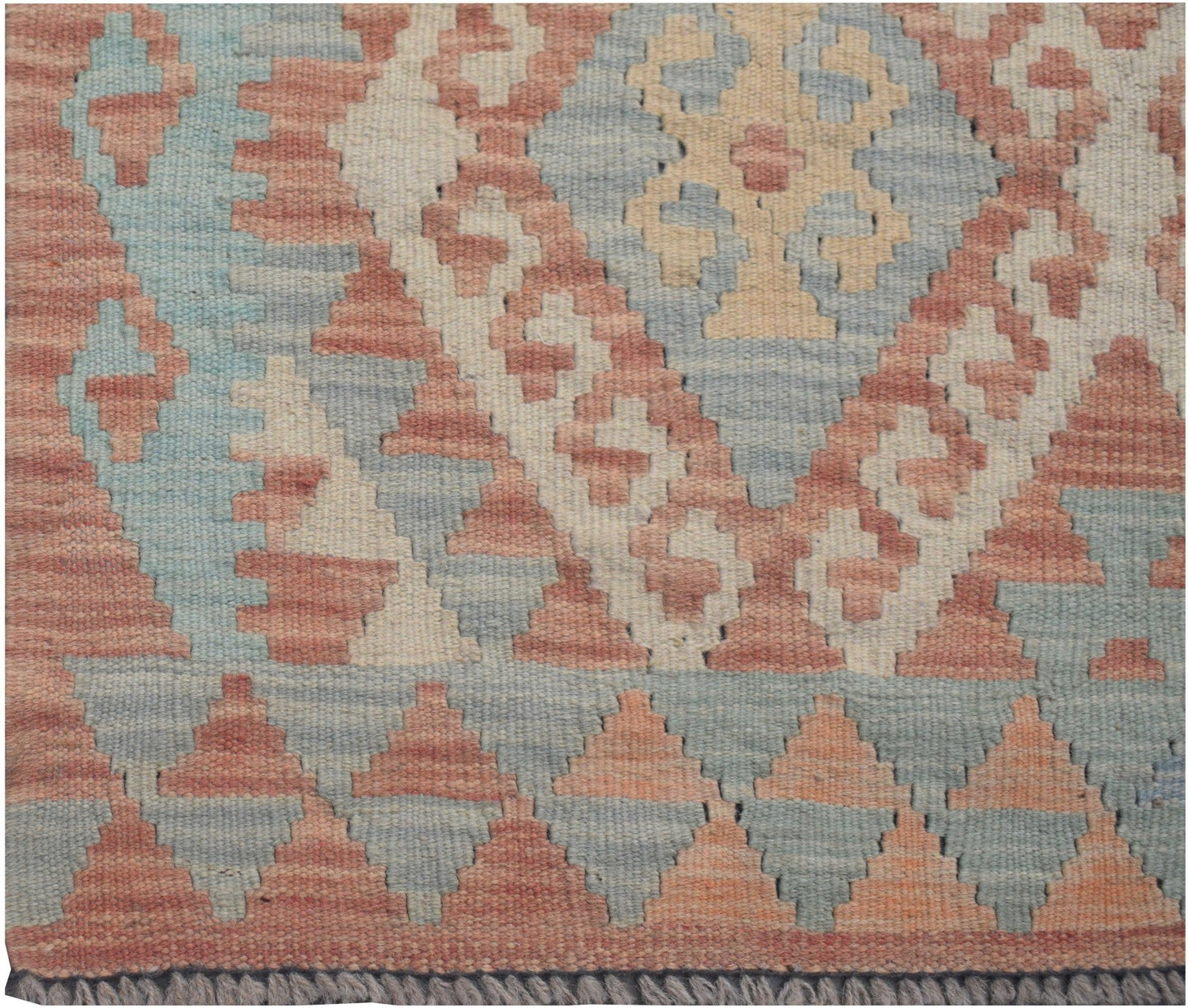 Handwoven Afghan Maimana kilim runner featuring a geometric pattern in muted red, blue, and cream.