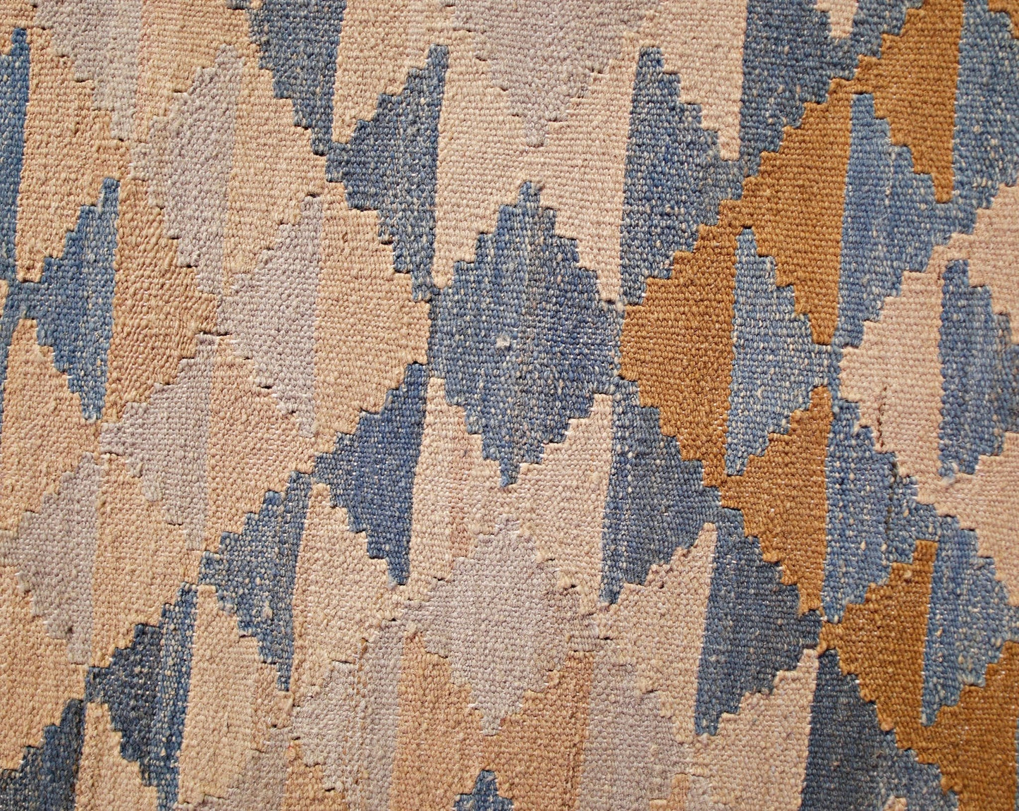 A handwoven Afghan Maimana kilim runner featuring a geometric diamond pattern in blue and tan.