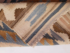 A close-up of a handwoven Afghan Maimana kilim runner featuring geometric patterns in wool.