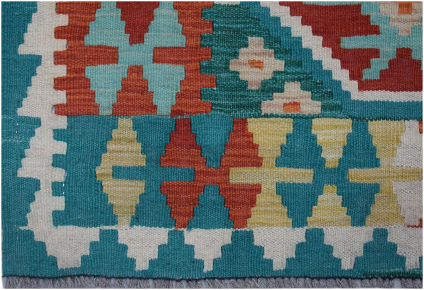 Handwoven Afghan Maimana kilim runner featuring a geometric pattern in vibrant wool colors.