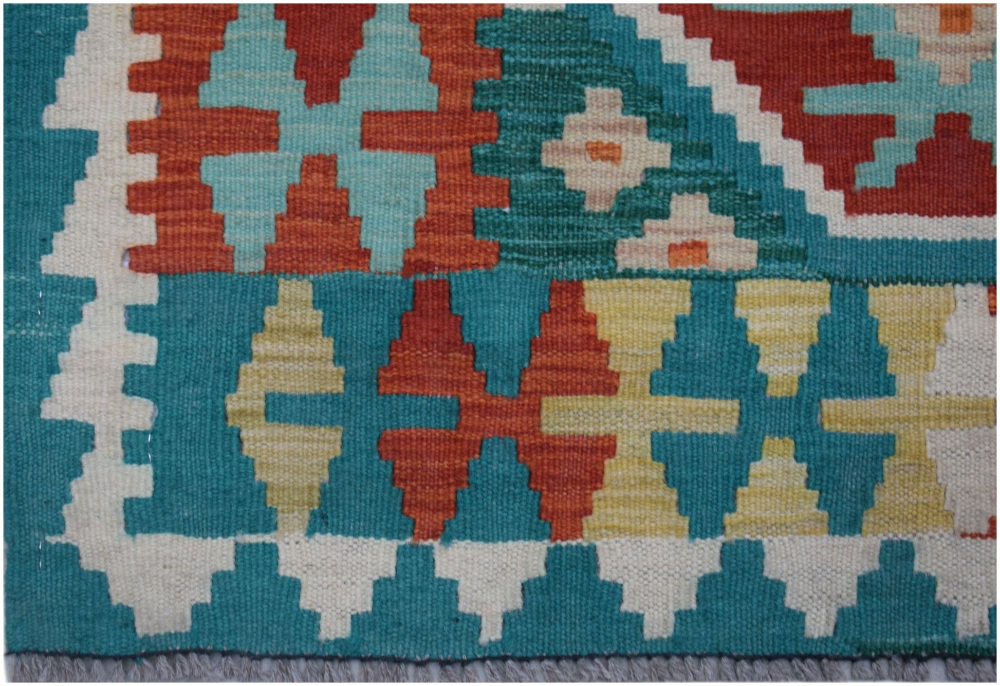 Handwoven Afghan Maimana kilim runner featuring a geometric pattern in vibrant wool colors.