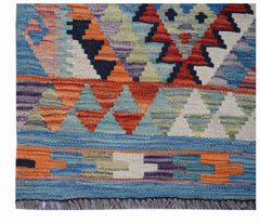 Handwoven Afghan Maimana wool kilim runner featuring colorful geometric patterns and fringe ends.