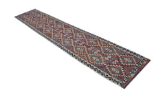 A long, handwoven Afghan Maimana wool runner featuring a colorful geometric diamond pattern.