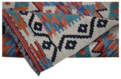 A handmade Afghan Maimana wool kilim runner featuring a geometric pattern in blue and orange.