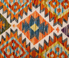 A close-up of a handmade Afghan Maimana kilim runner featuring a vibrant geometric diamond pattern.