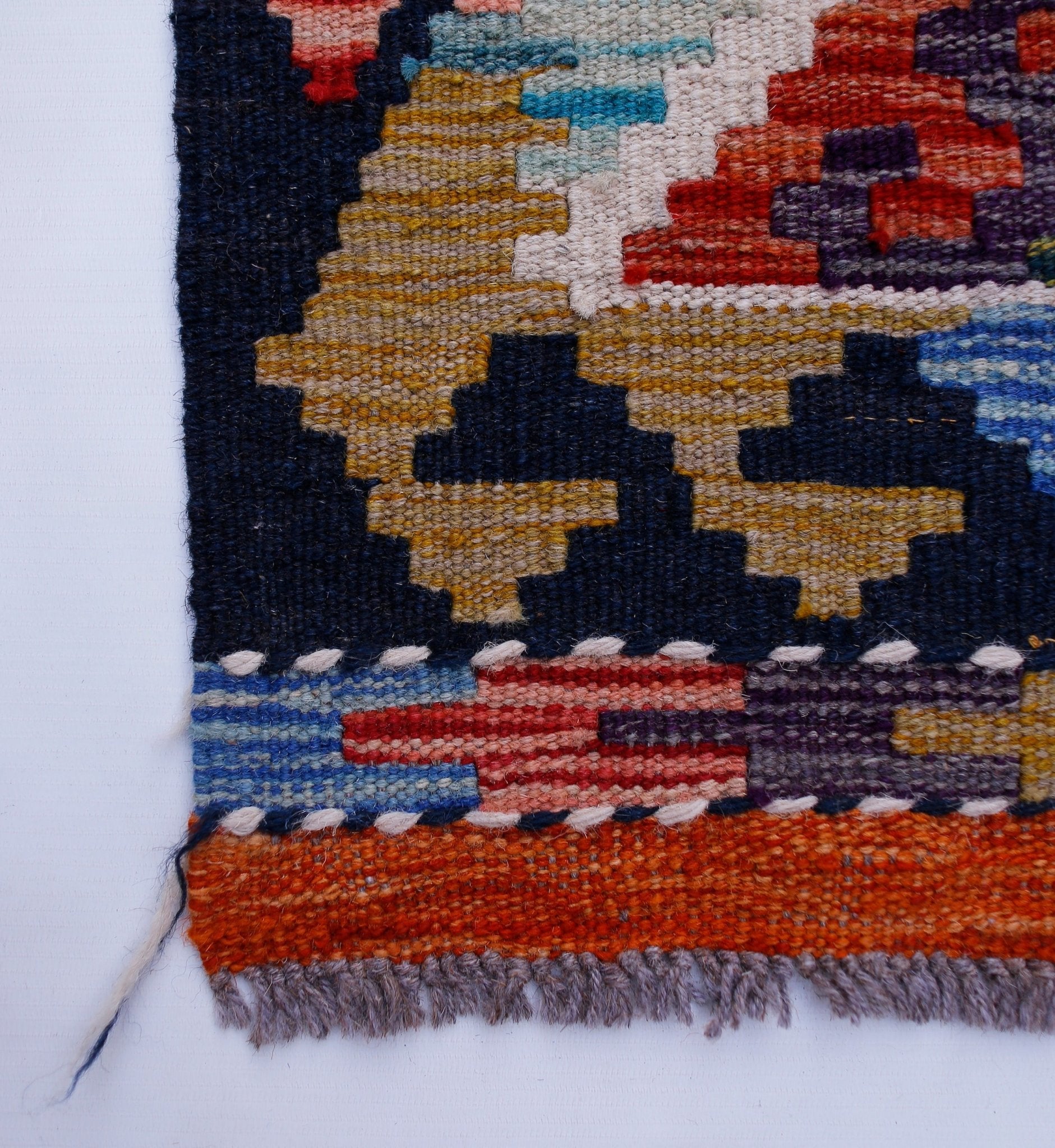 A close-up of a handwoven Afghan Maimana wool kilim runner featuring geometric patterns.