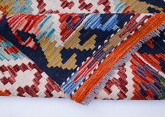 A folded Afghan Maimana kilim runner featuring a vibrant geometric pattern in wool.