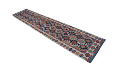 A long, handmade Afghan Maimana wool runner rug featuring a colorful geometric diamond pattern.