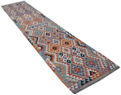 A handmade Afghan Maimana wool runner rug featuring a colorful geometric diamond pattern.