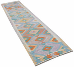 A handmade Afghan Maimana wool runner rug featuring a colorful geometric diamond pattern.