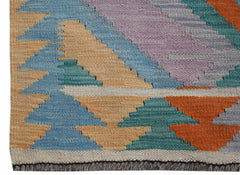 A handmade Afghan Maimana Kilim runner featuring a geometric pattern in vibrant, multicolored wool.