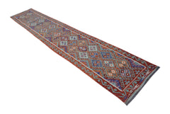 A handmade Afghan Maimana kilim runner featuring a geometric pattern in red, blue, and cream tones.